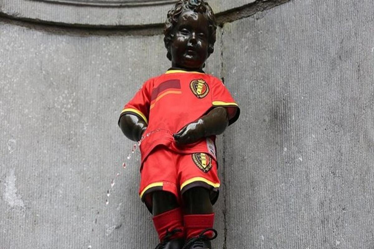 Una estatua de un niño con uniforme colgada en una pared.