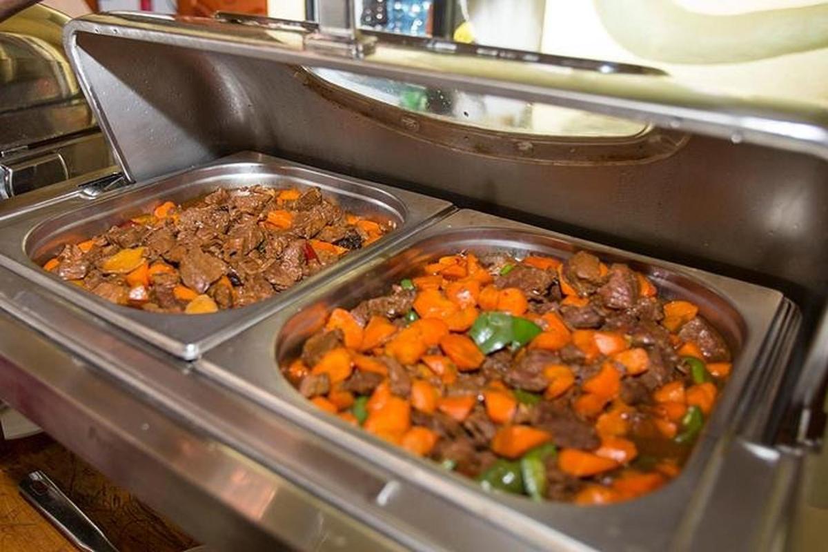 duas bandejas de carne e vegetais no forno