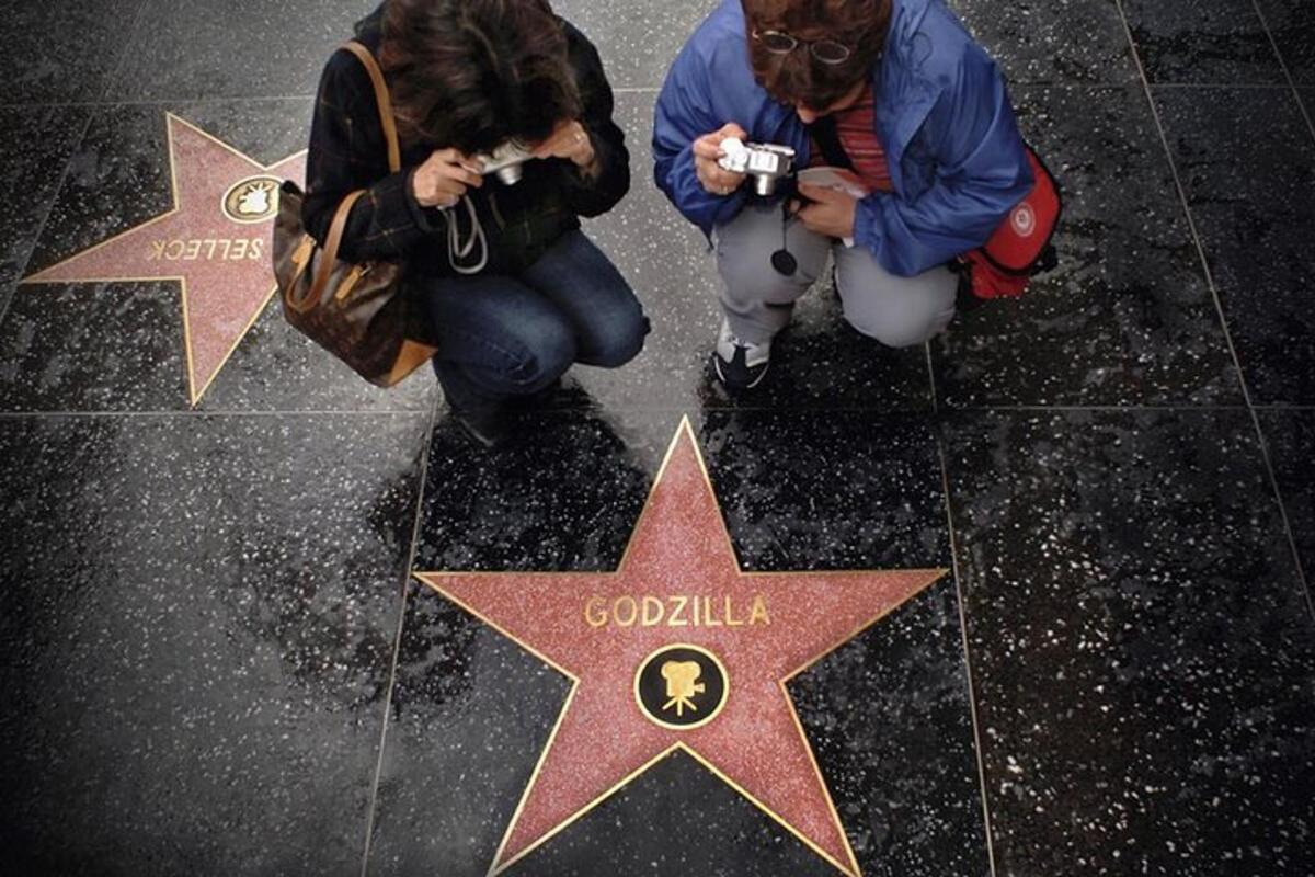 dues persones fent fotos d'una estrella al terra