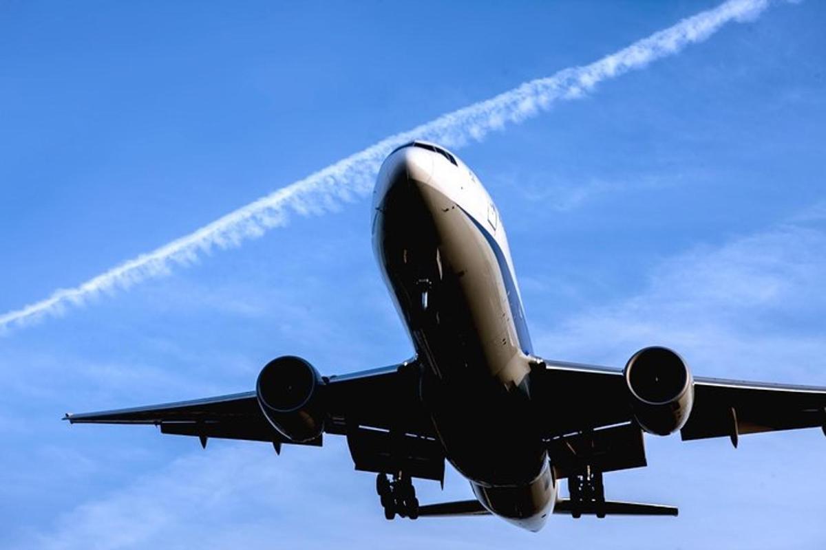 ett flygplan som flyger på himlen med ett rökspår