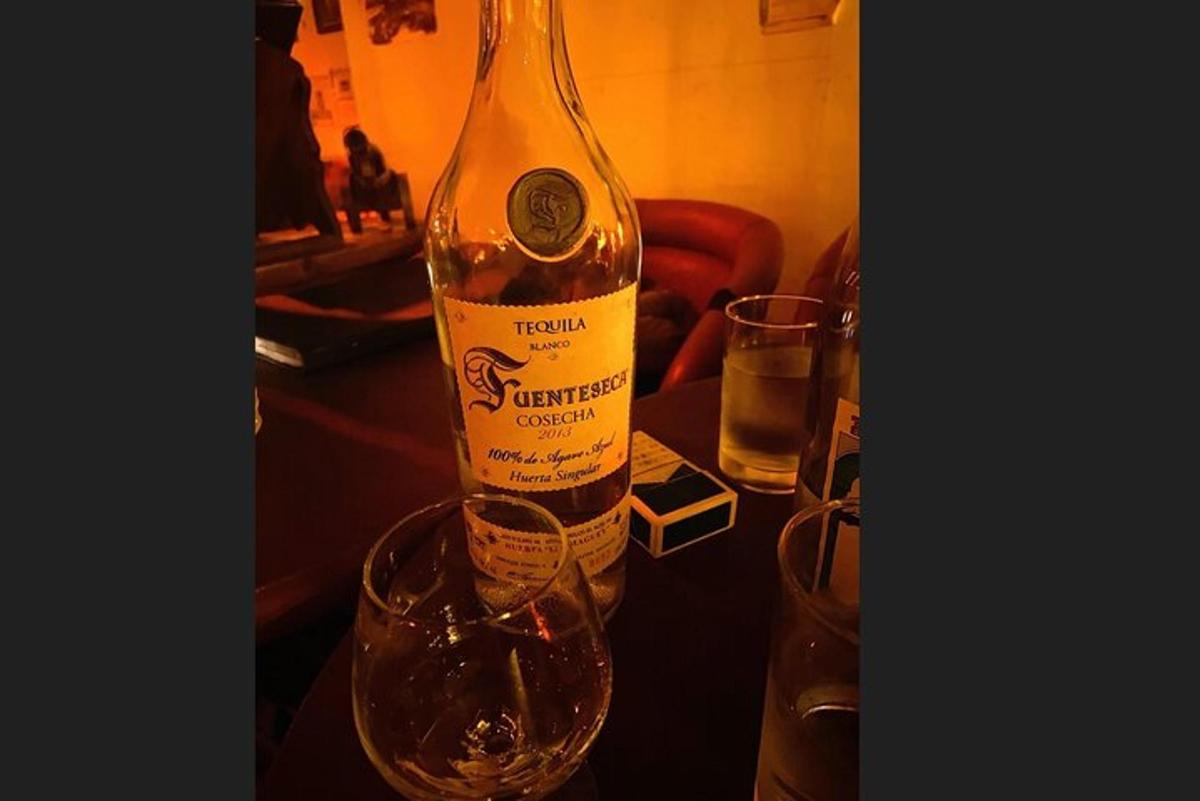 a bottle of wine sitting on a table with a glass