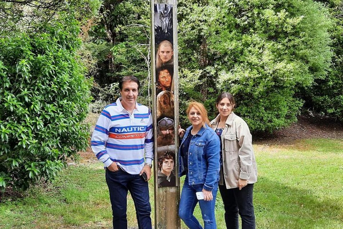 skupina lidí stojící vedle totemu