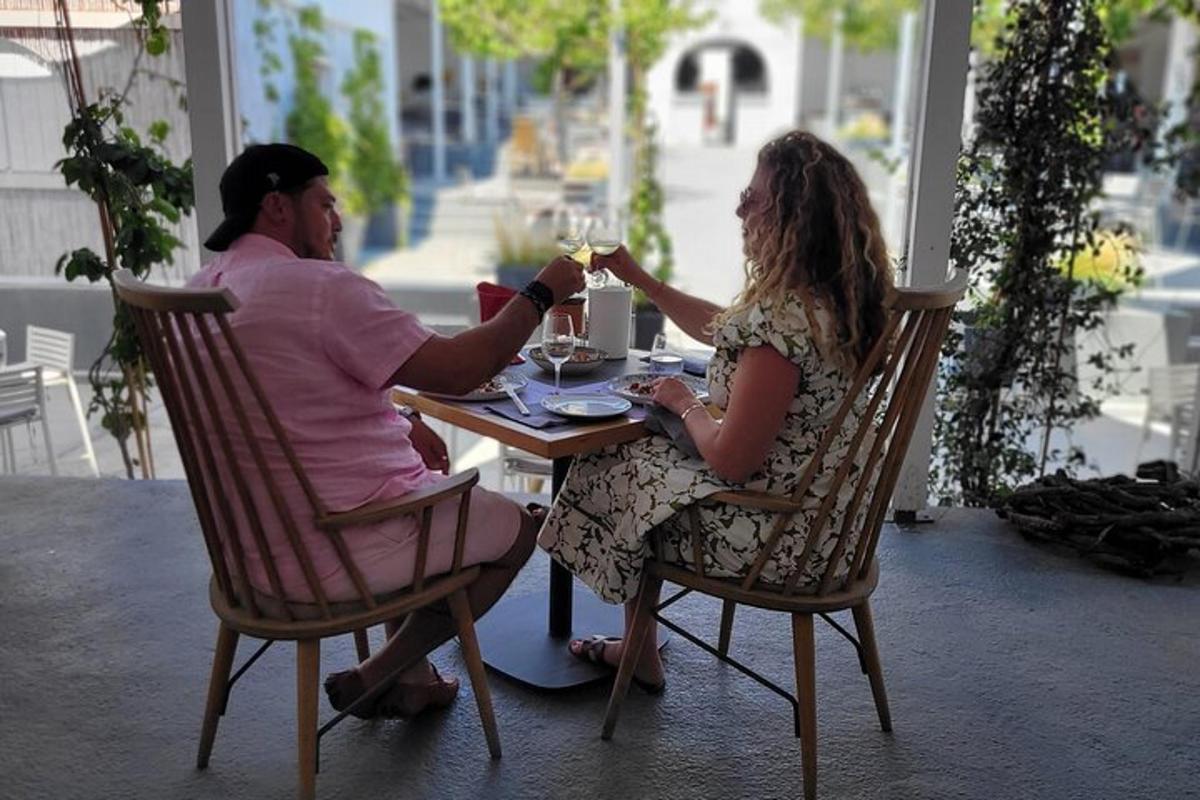 due persone sedute a un tavolo con bicchieri di vino