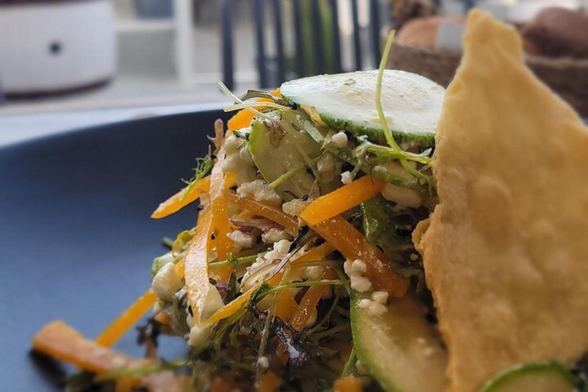 un panino su un piatto blu con carote e verdure