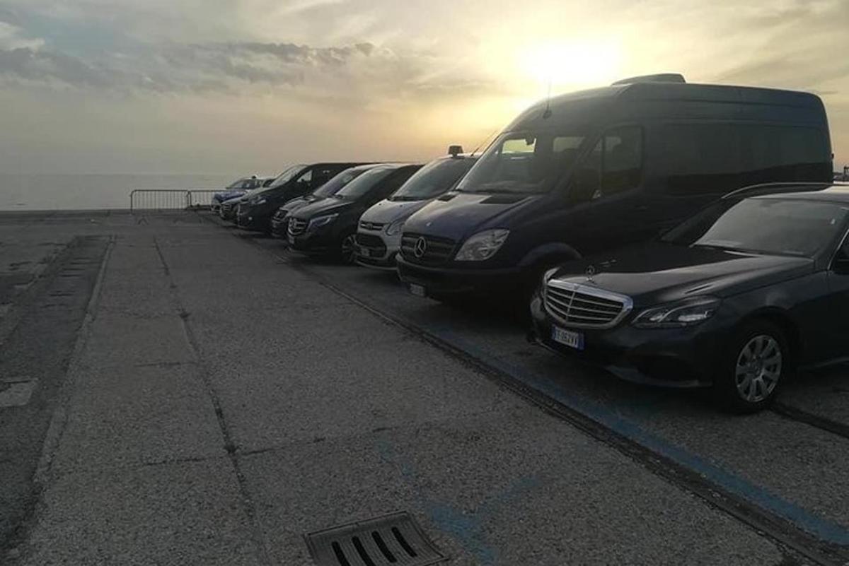 en række parkerede biler parkeret ved siden af havet