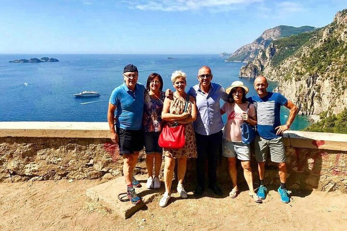 eine Gruppe von Menschen, die auf einer Klippe für ein Foto posieren