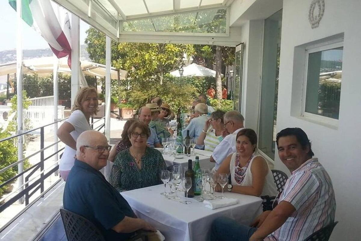 cilvēku grupa, kas sēž pie galda restorānā