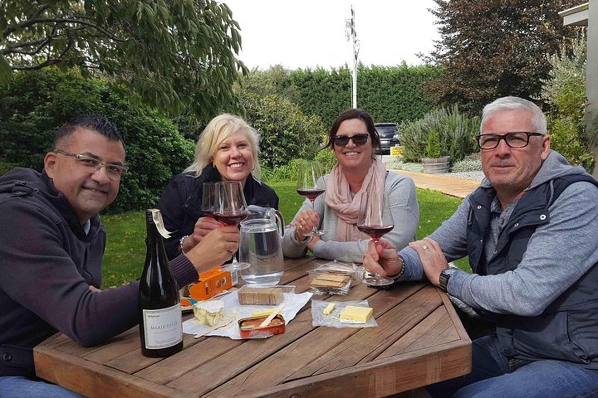 un grup de persones assegudes al voltant d'una taula amb copes de vi