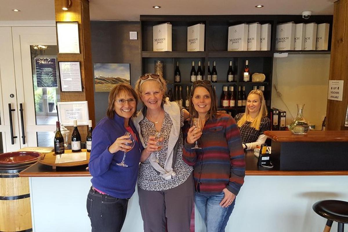 quatre dones dretes en un bar amb copes de vi