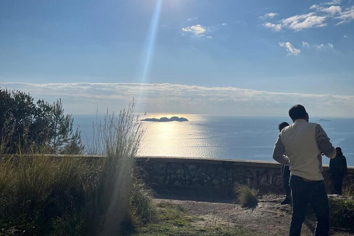 muž stojící na kopci a dívající se na oceán