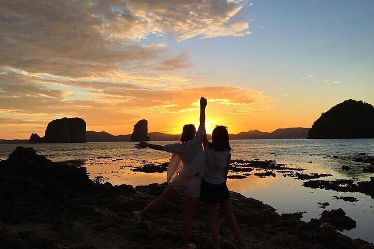 夕暮れの浜辺に立つ二人の女性