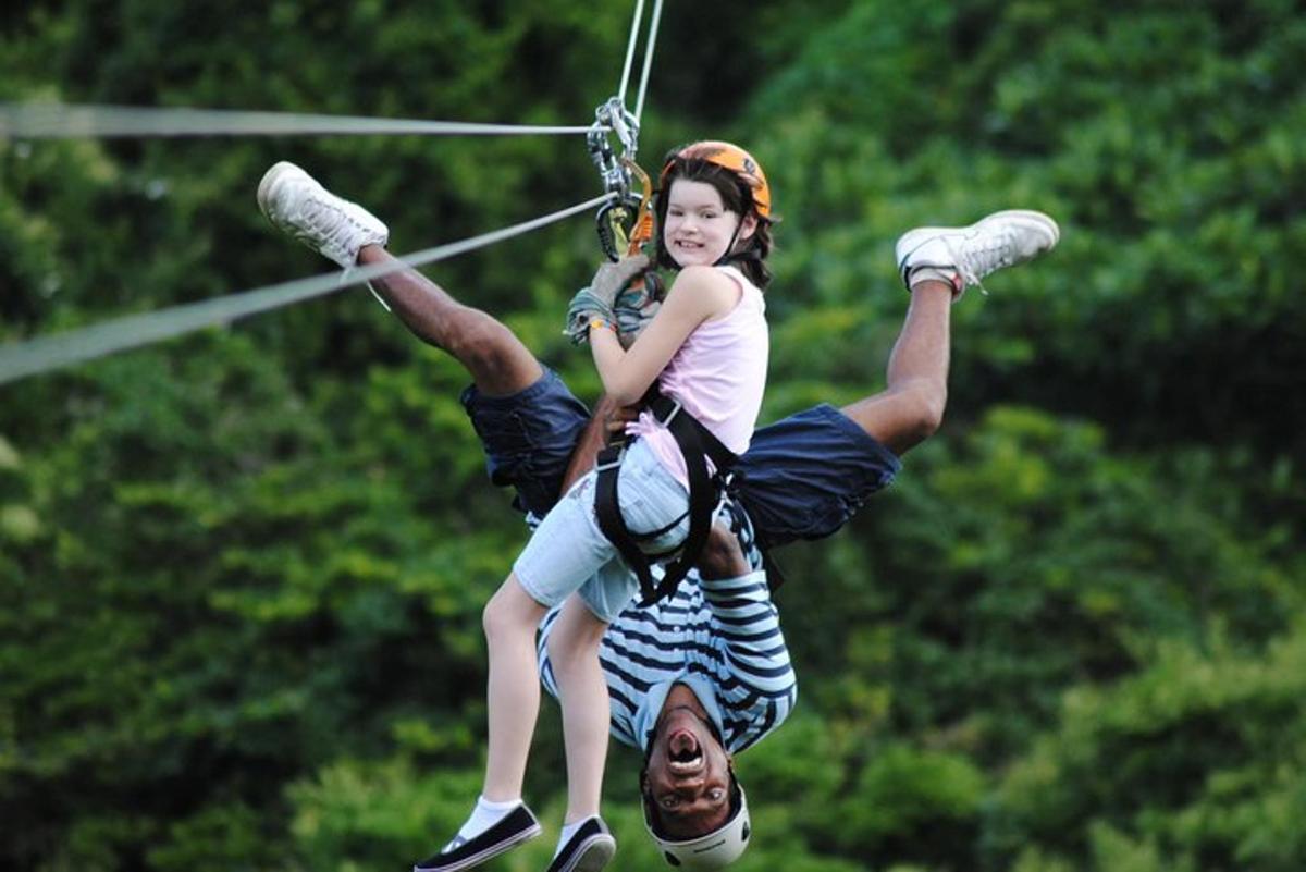 a young girl and a man on a zip line