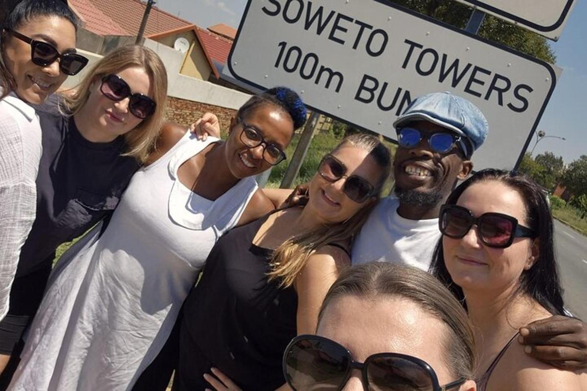 un gruppo di persone in posa per una foto davanti a un cartello