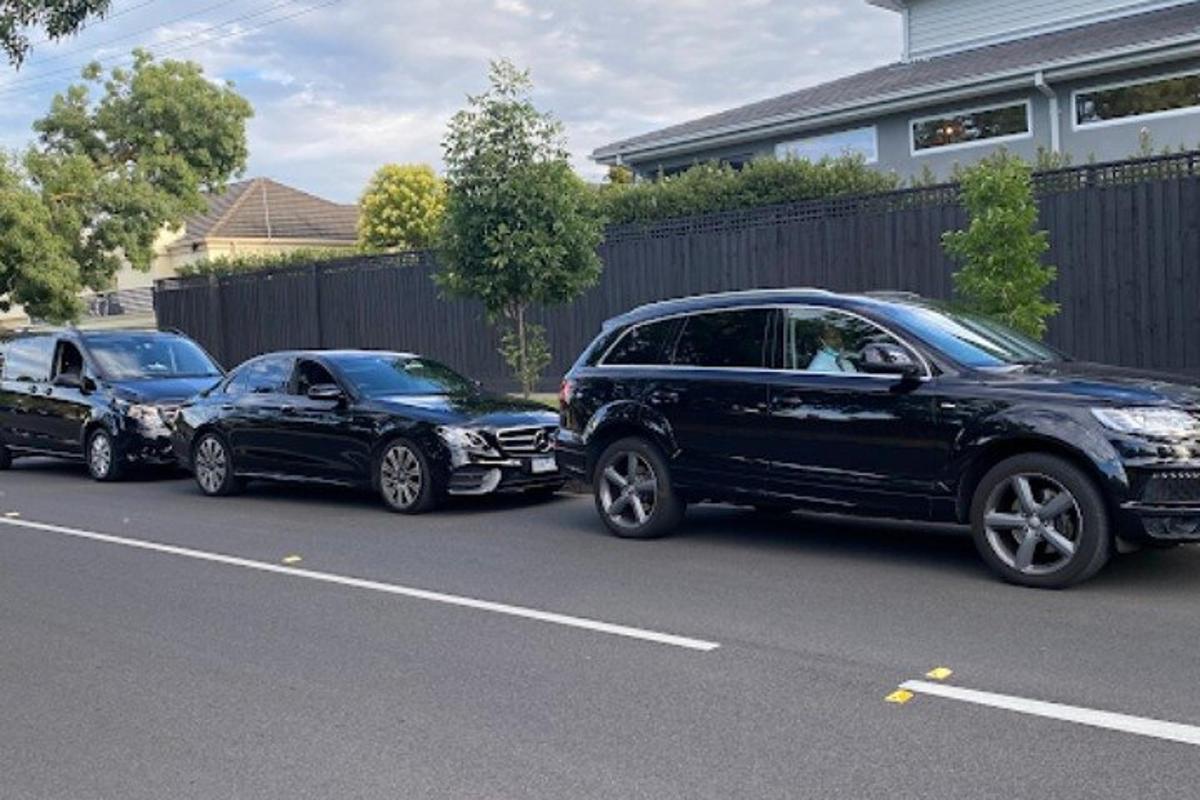 tre biler parkert på siden av en gate