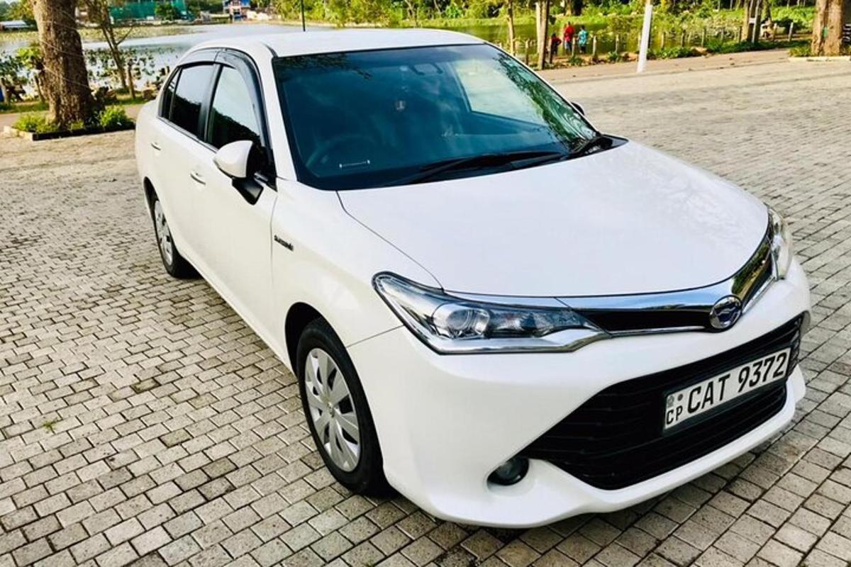 bílé auto zaparkované na cihlové silnici