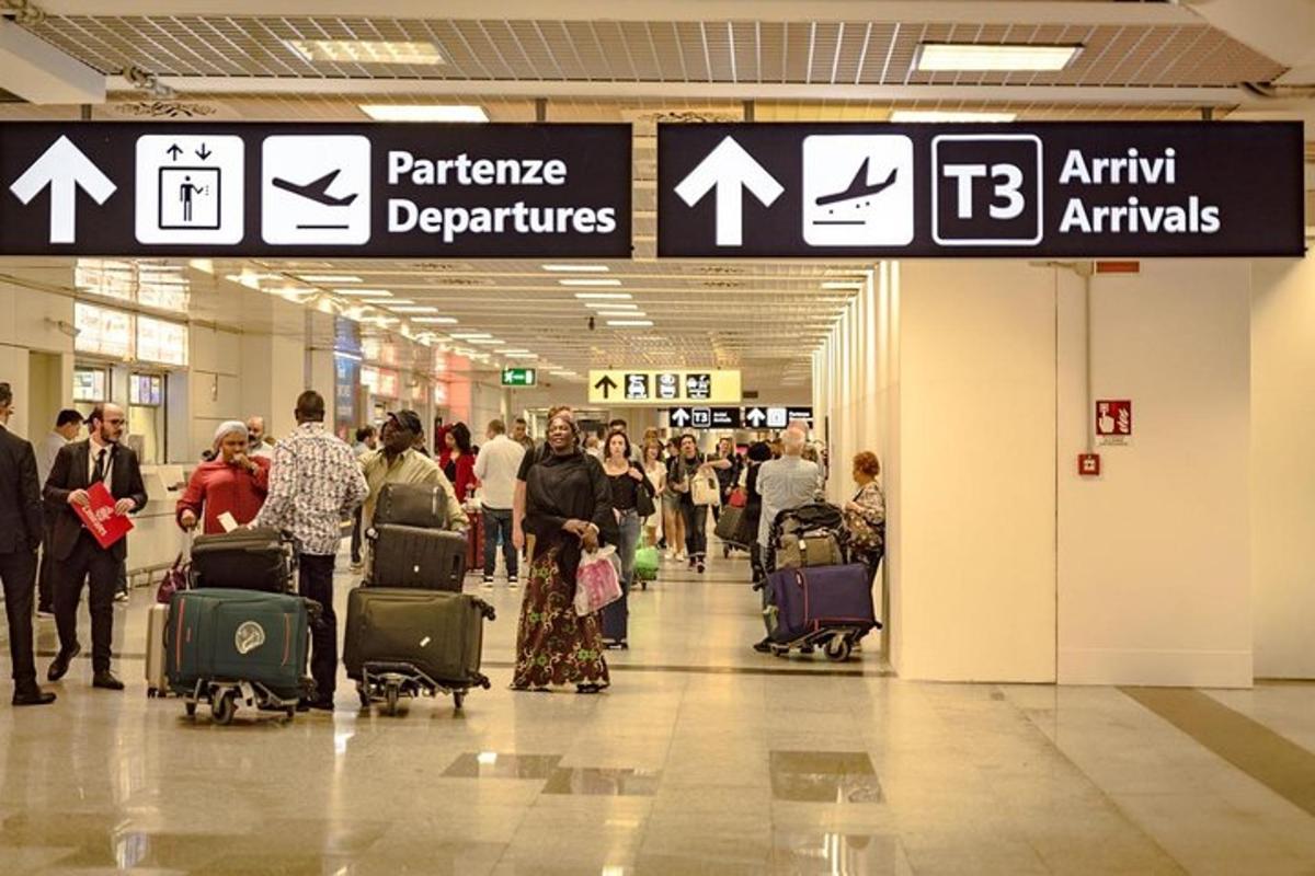 grupp inimesi, kes jalutavad läbi lennujaama oma pagasiga