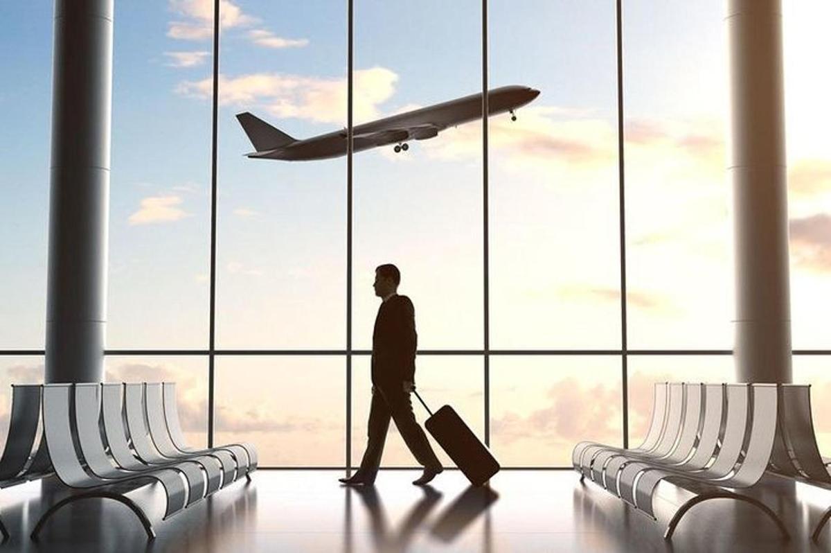un homme marchant dans un aéroport en regardant un avion