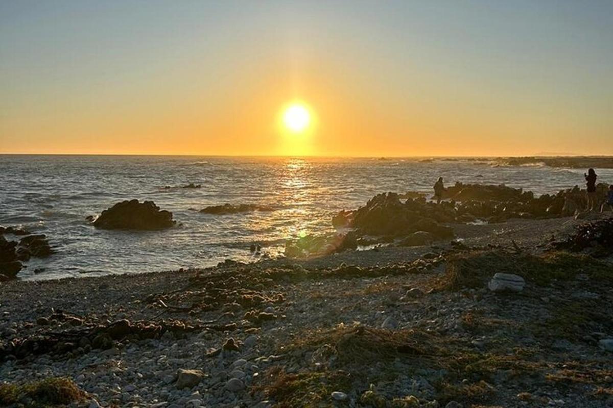 Západ slunce nad oceánem s lidmi na pláži