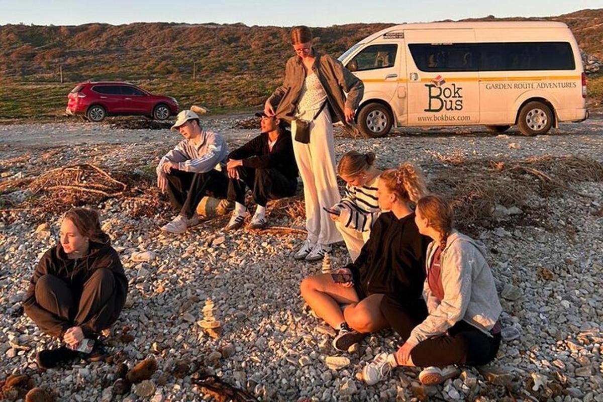 skupina lidí sedících na skalách poblíž dodávky