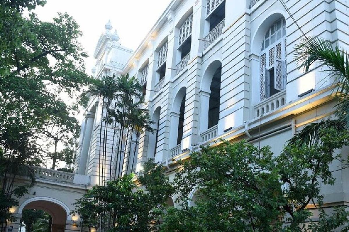 sebuah bangunan putih besar dengan pepohonan di depannya