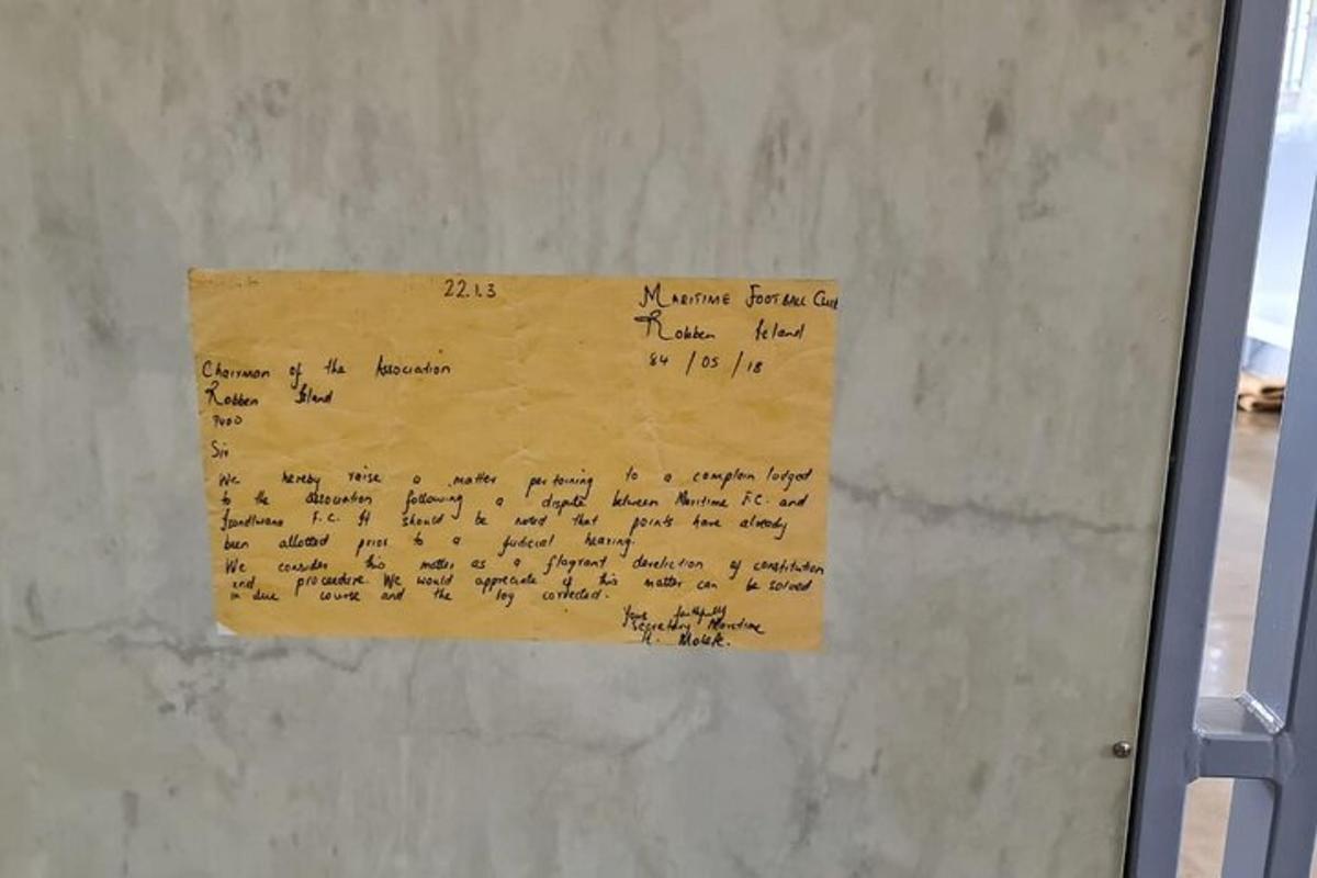 Un trozo de papel en una pared con algo escrito en él.