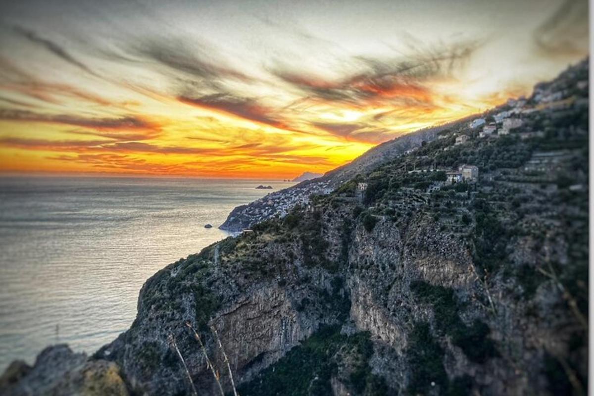 un tramonto su una montagna con l'oceano