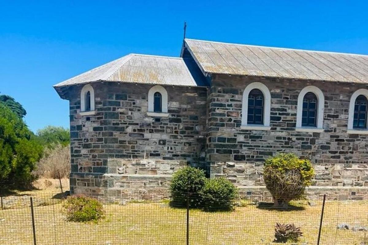 sebuah gereja batu tua dengan pagar di depannya
