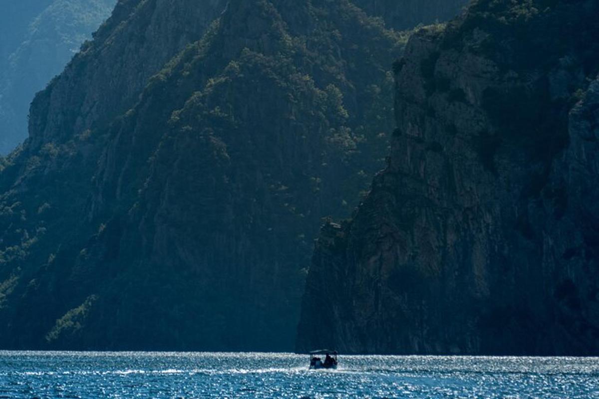 una barca in acqua accanto a una montagna