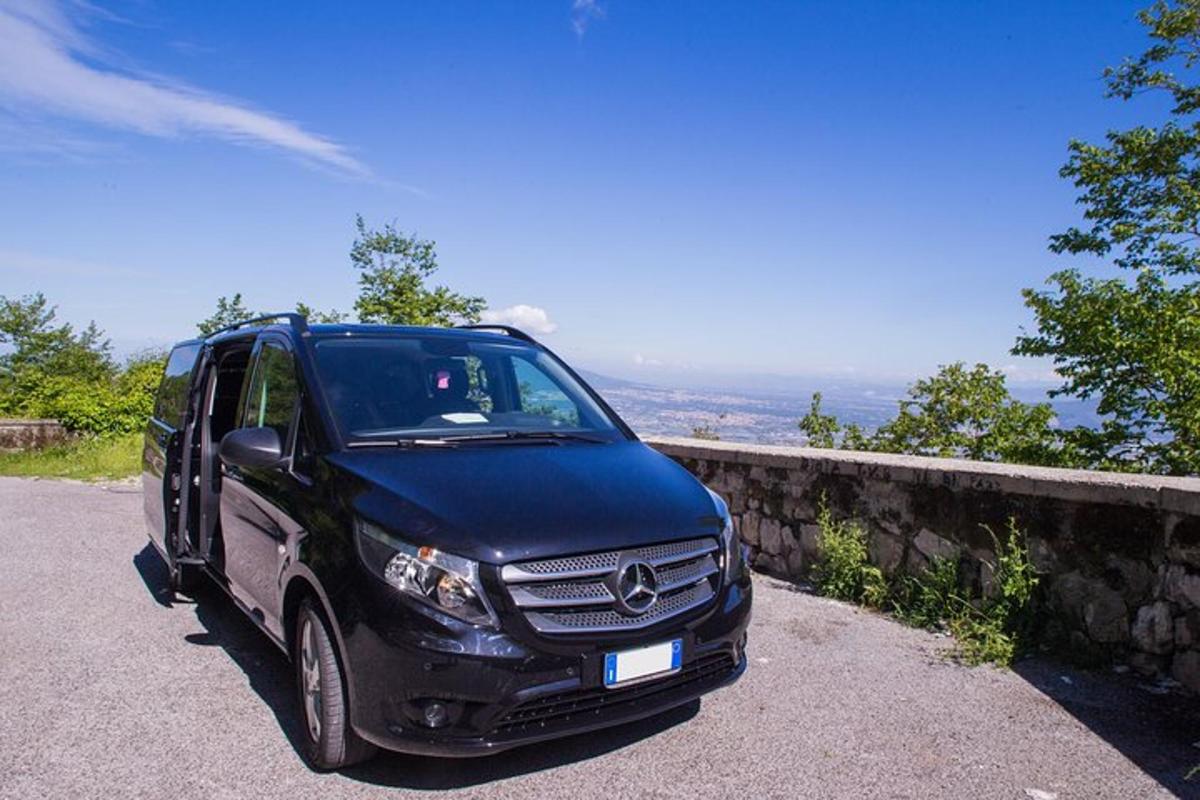 črn kombi parkiran ob kamnitem zidu