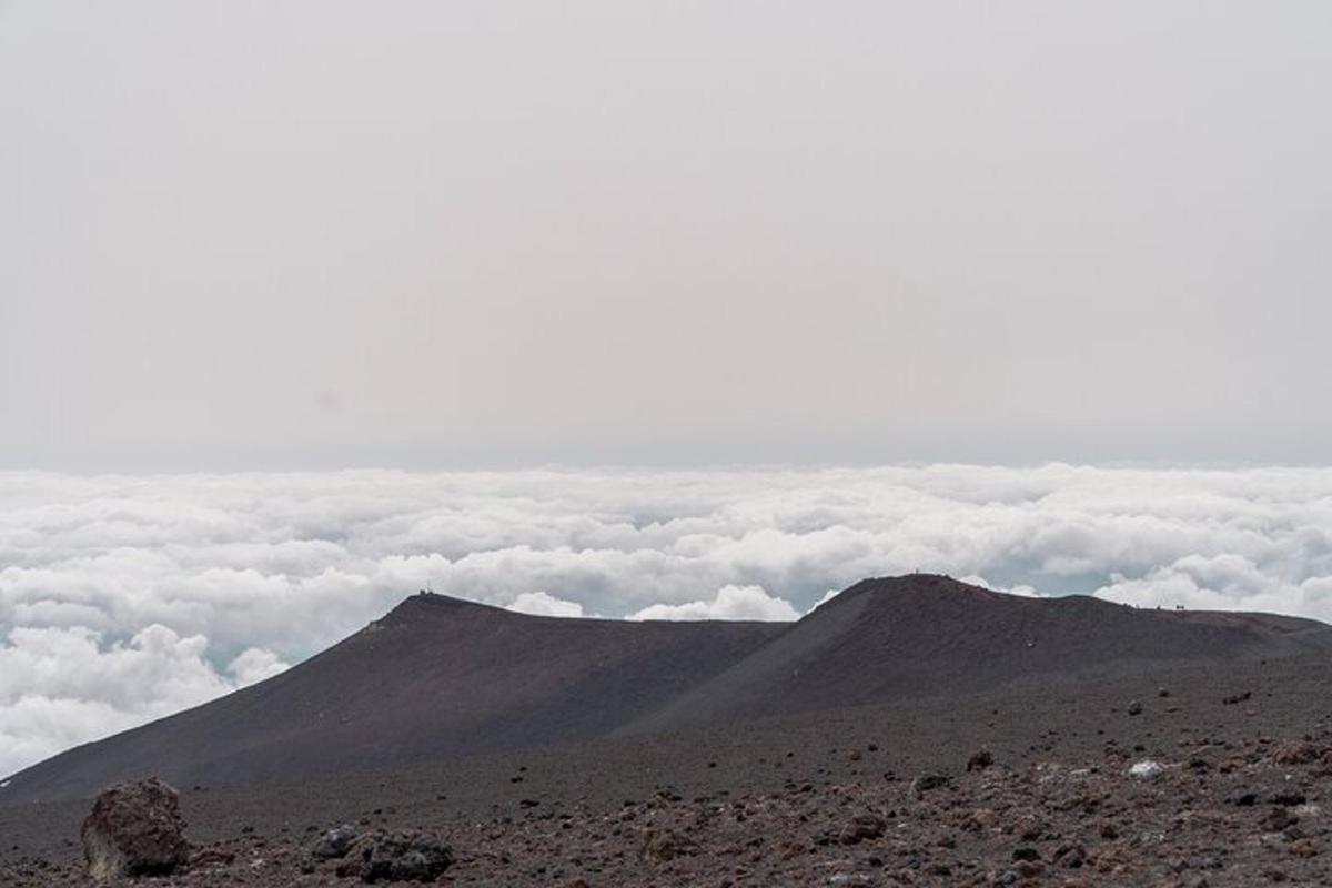 uma vista de uma montanha com nuvens ao fundo