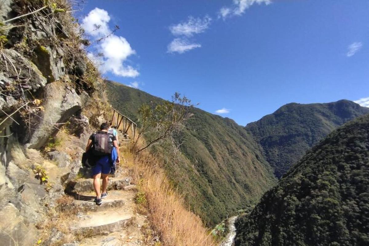 un hombre caminando por un sendero en una montaña