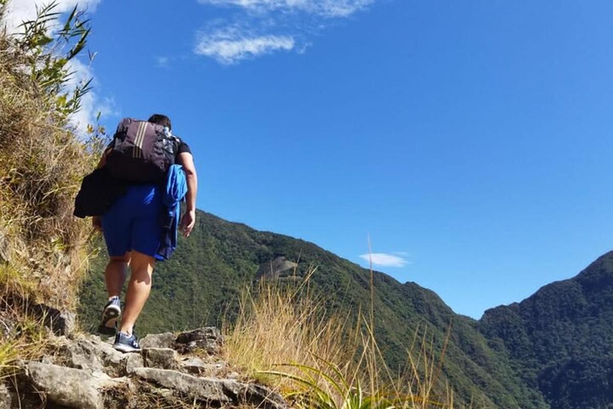 Un hombre con una mochila caminando por un sendero de montaña
