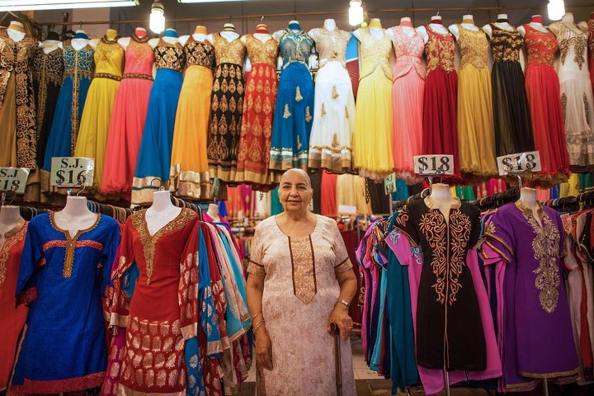 seorang wanita berdiri di hadapan paparan pakaian di sebuah kedai