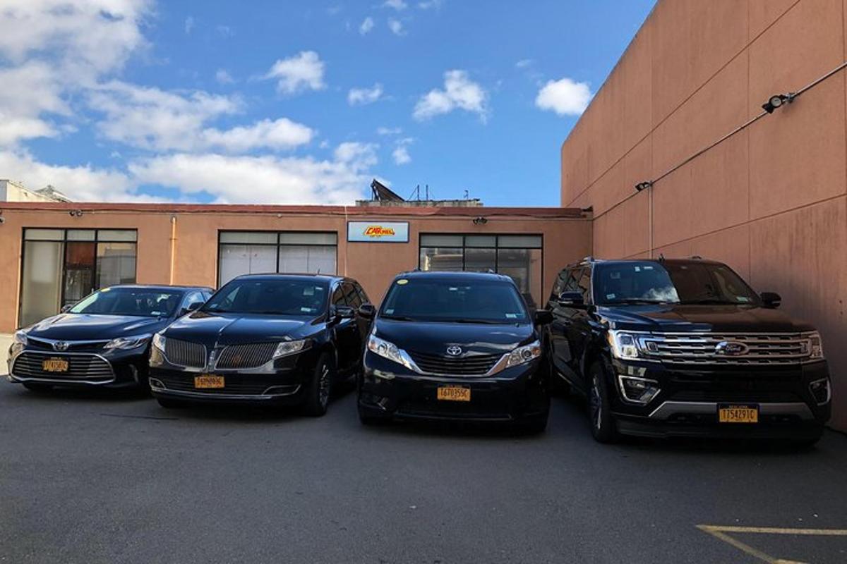 um grupo de quatro carros estacionados em frente a um prédio