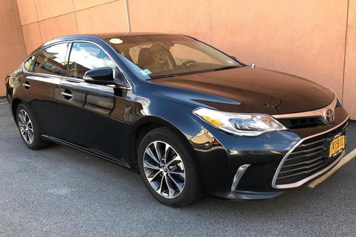 um carro azul e preto estacionado ao lado de um prédio