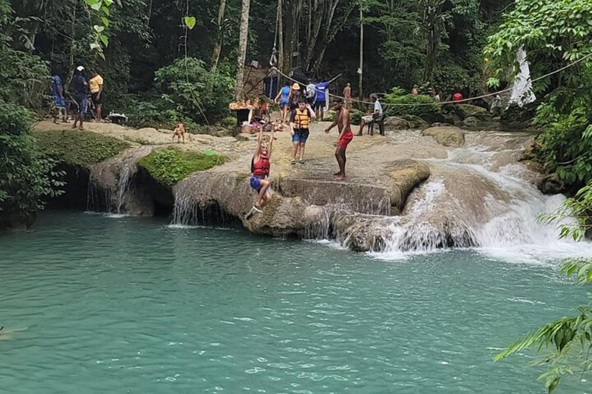 a group of people jumping into a waterfall in a river