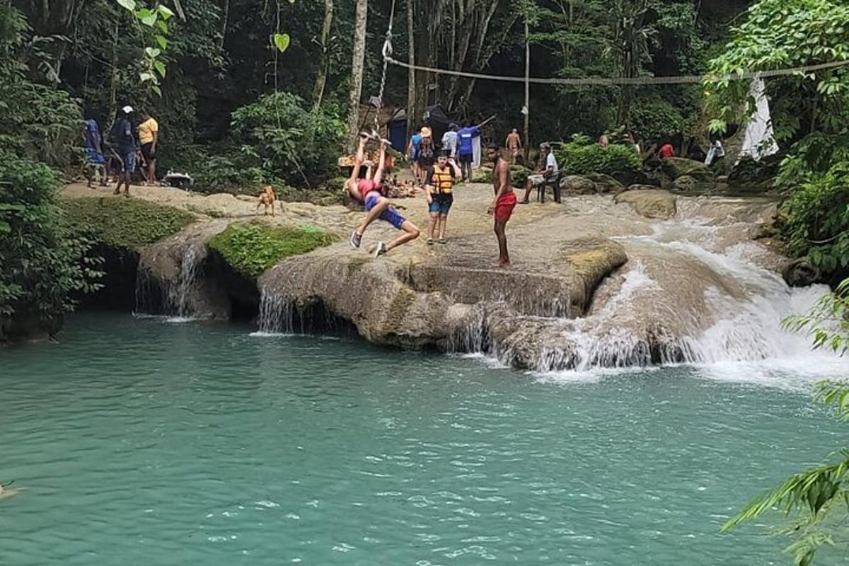 sekumpulan orang bermain air berhampiran air terjun