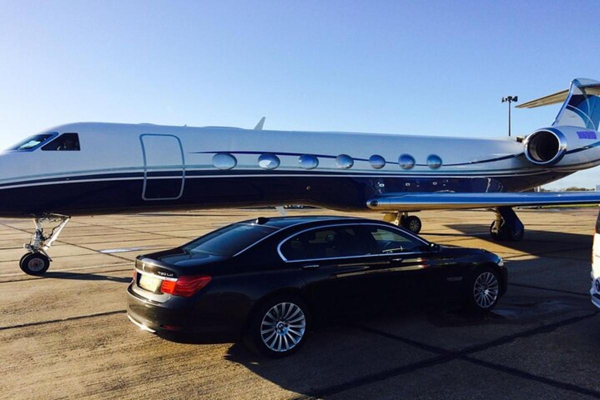 un'auto nera parcheggiata accanto a un aereo