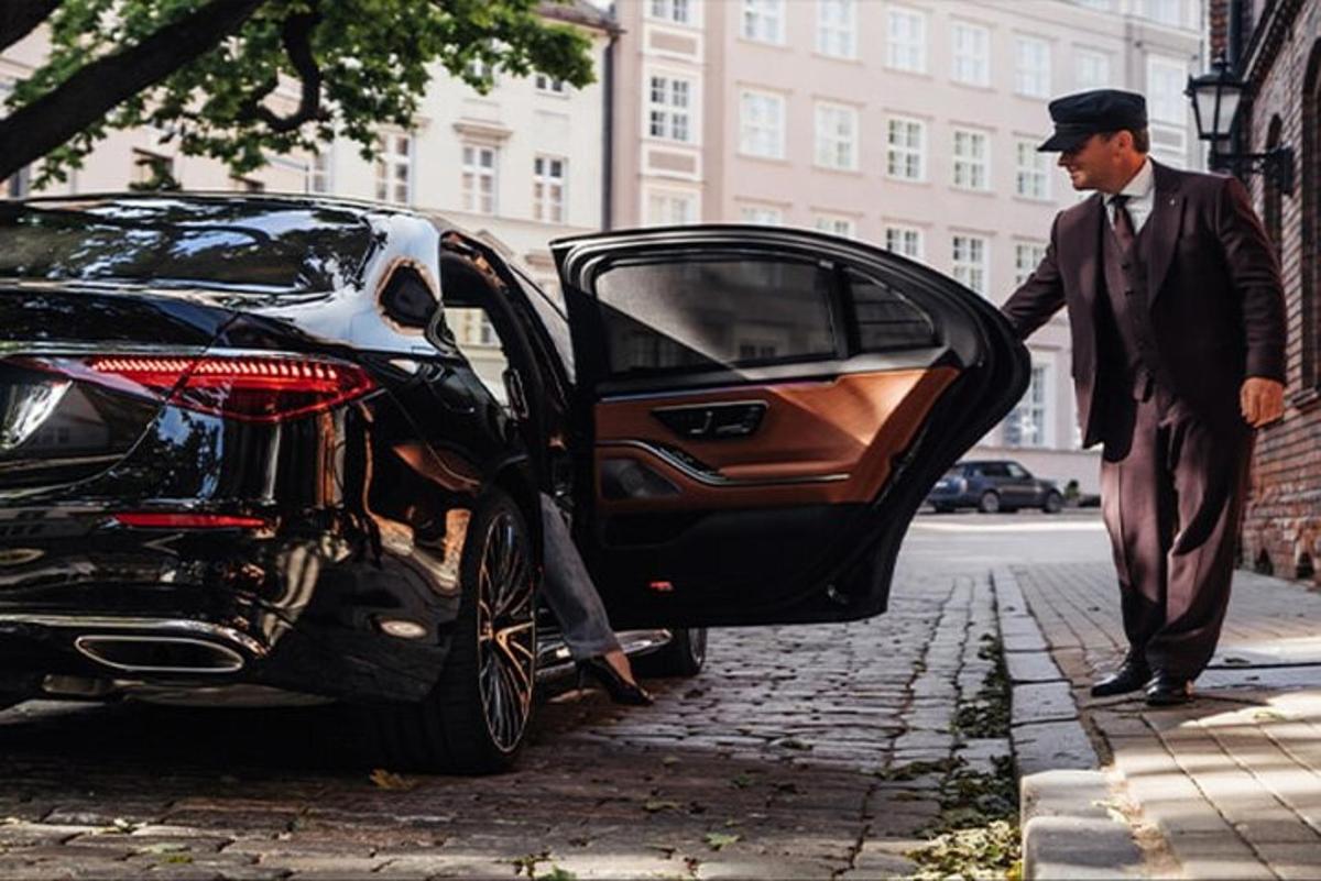 seorang lelaki berdiri di sebelah kereta dengan pintunya terbuka