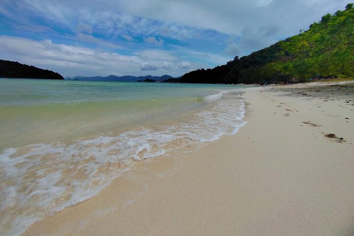 egy strand lábnyomokkal a homokban és a vízben