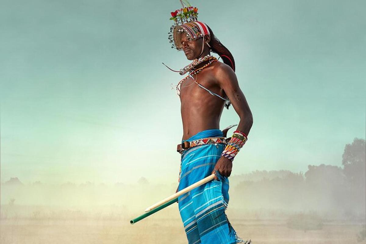 Un hombre con traje indio sosteniendo un palo
