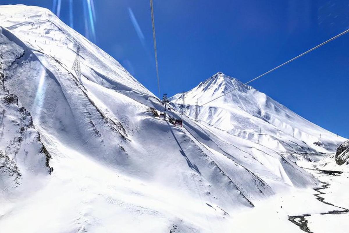 un munte acoperit de zăpadă peste care zboară un zmeu