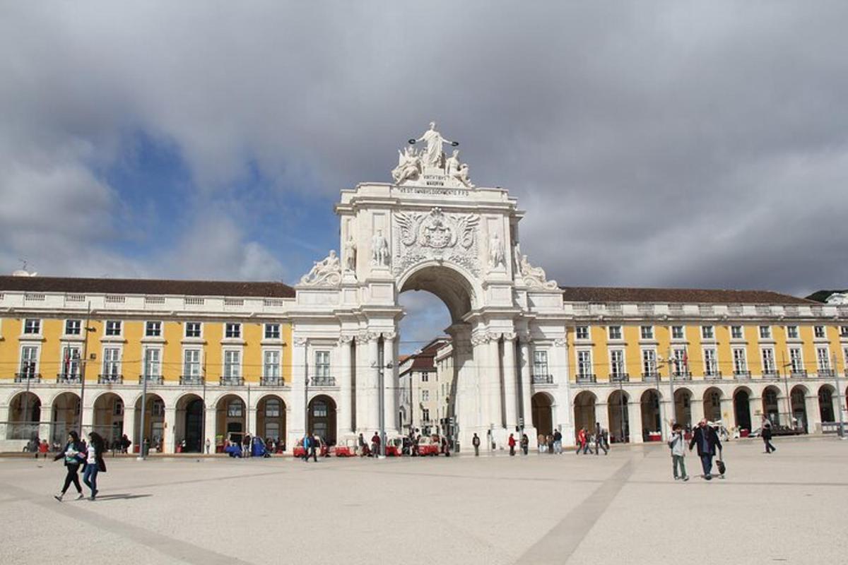 Un gran edificio con un arco con gente caminando alrededor.