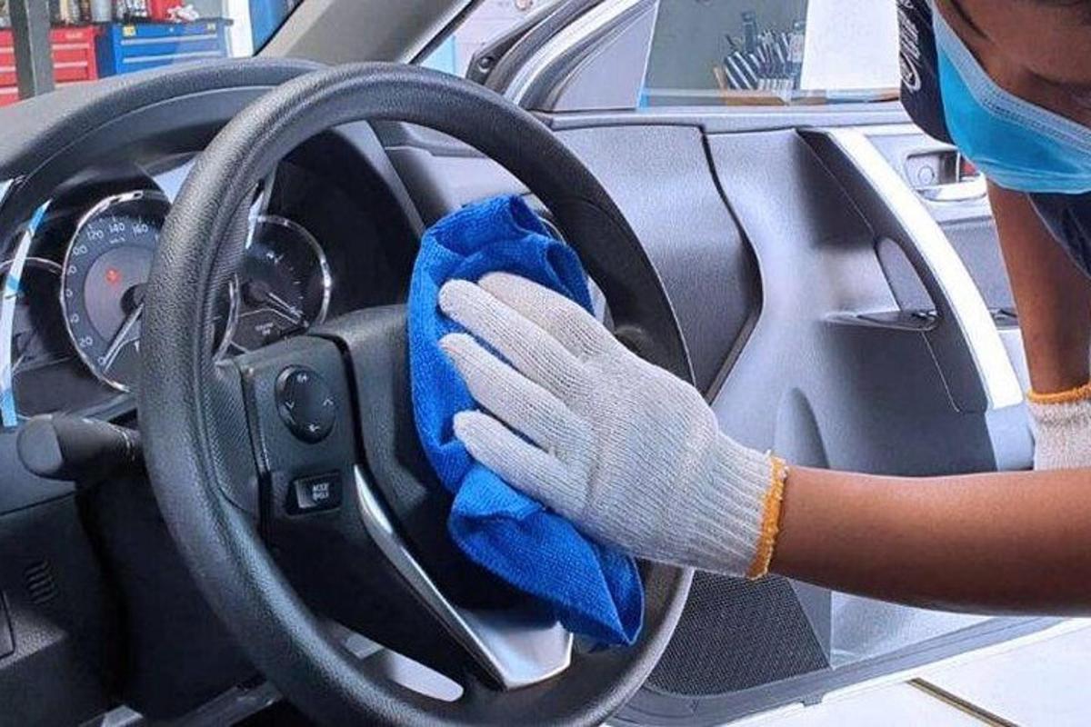 člověk čistí volant auta