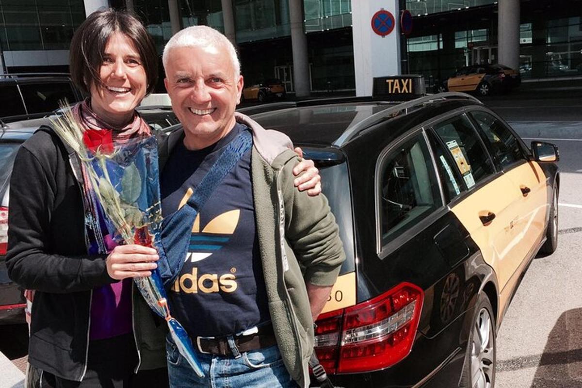 Un hombre y una mujer de pie junto a un coche.