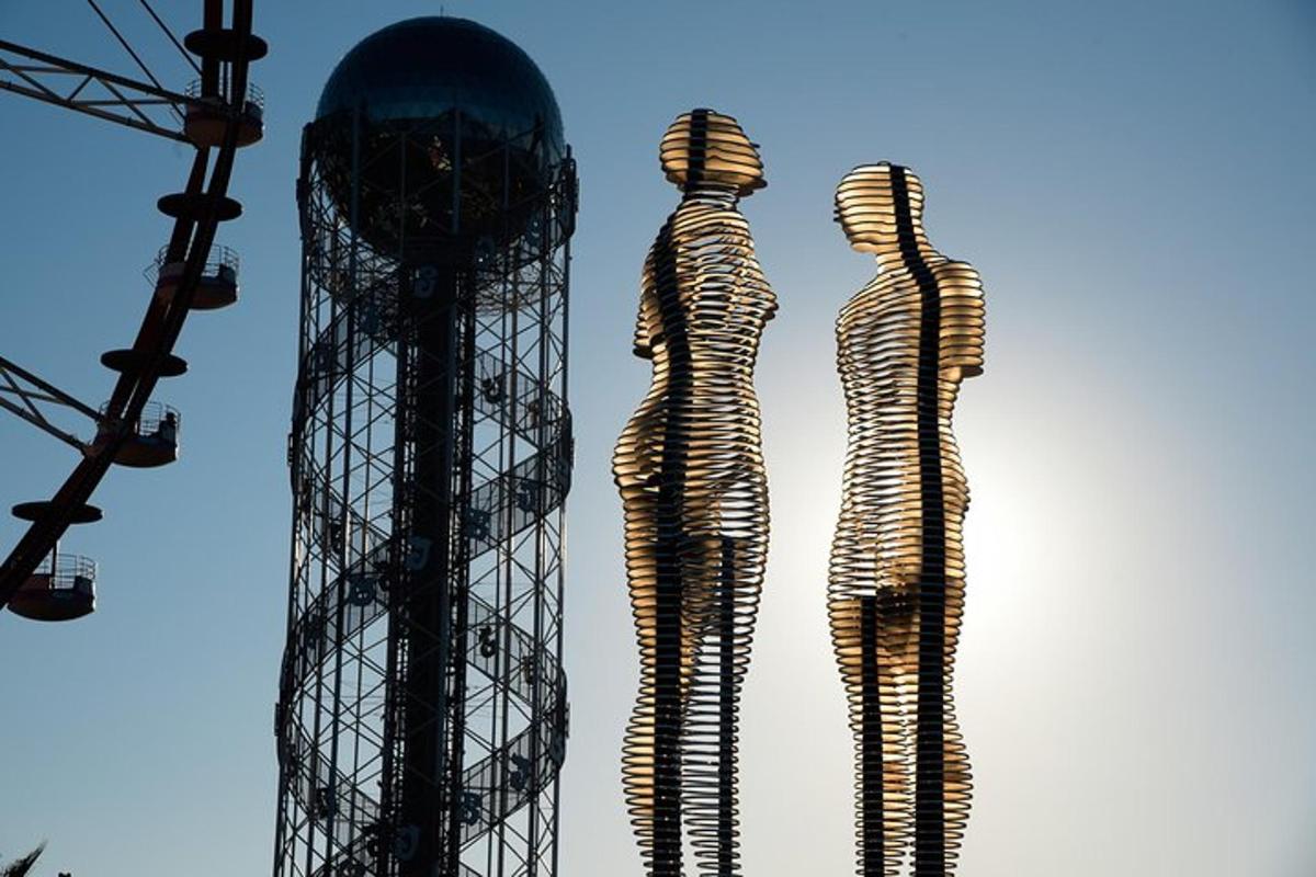two metal mannequins standing next to two towers