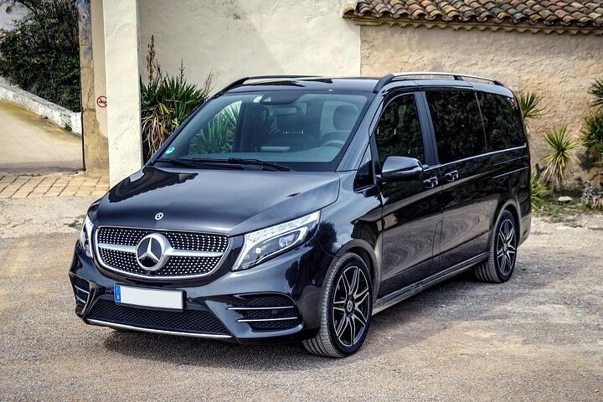 Černé auto Mercedes Benz zaparkované na příjezdové cestě