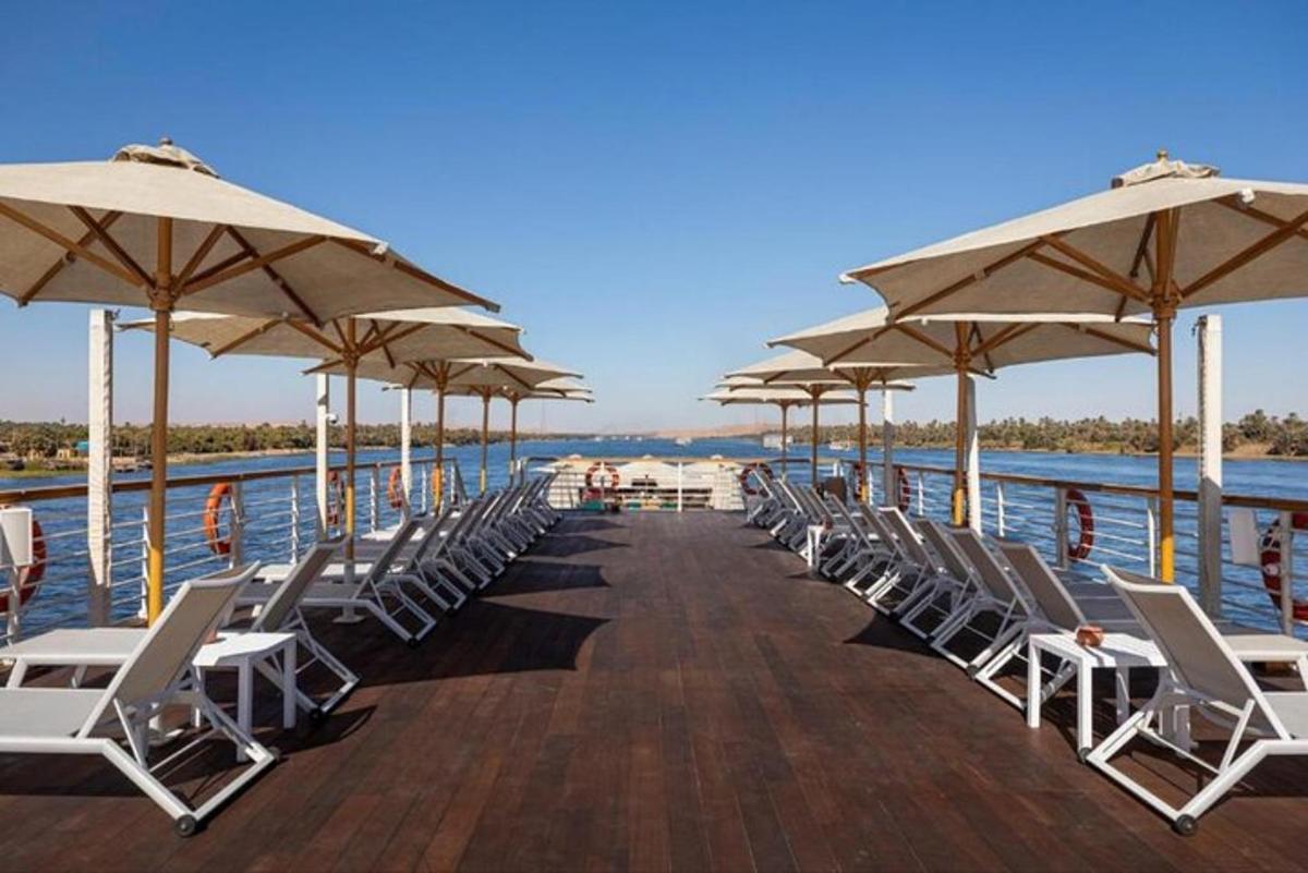 a pier with chairs and umbrellas on the water