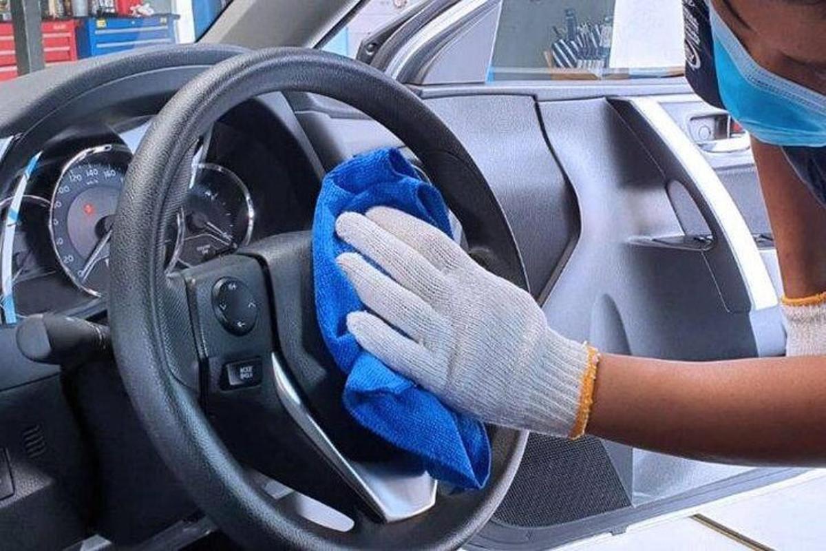 Ένα άτομο καθαρίζει το τιμόνι ενός αυτοκινήτου