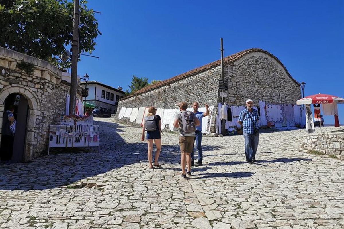 skupina ľudí kráčajúcich po kamennej ulici